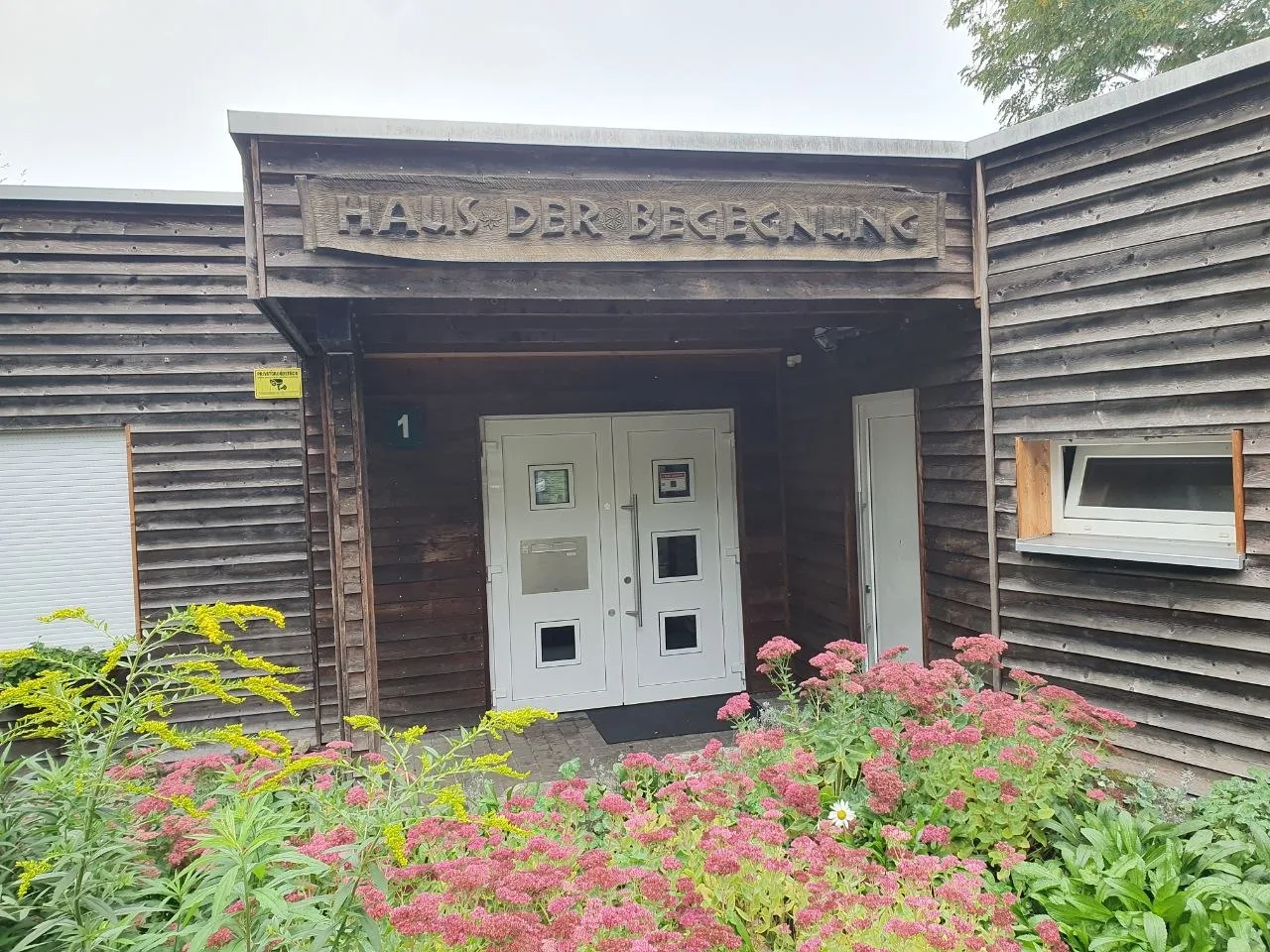 Eingang des Vereinshauses Haus der Begegnung mit Besucherschild
